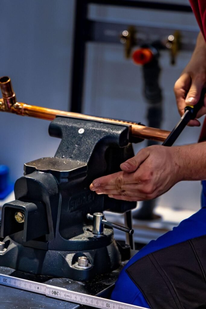 Plumber bending copper pipe for a pipe repair